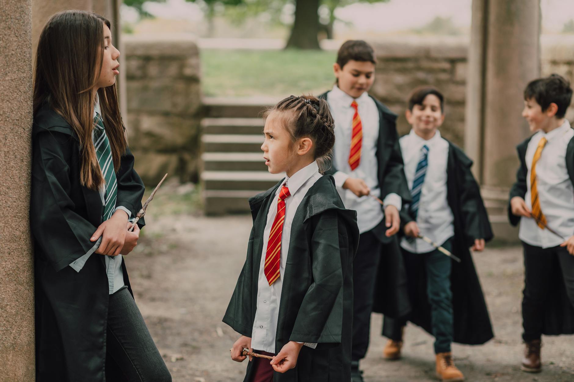 kids wearing black coats and holding a wooden stick