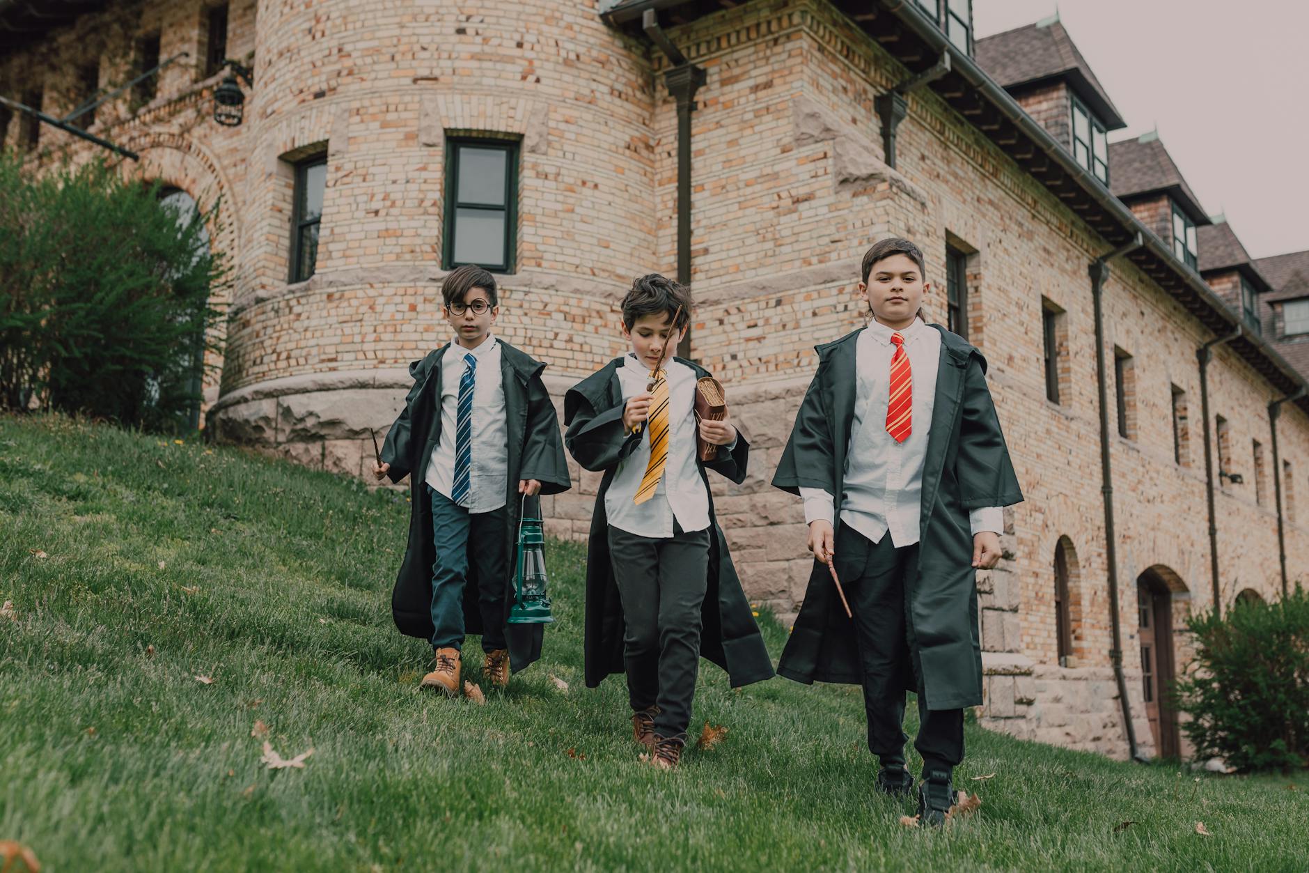 boys in black robes holding wands