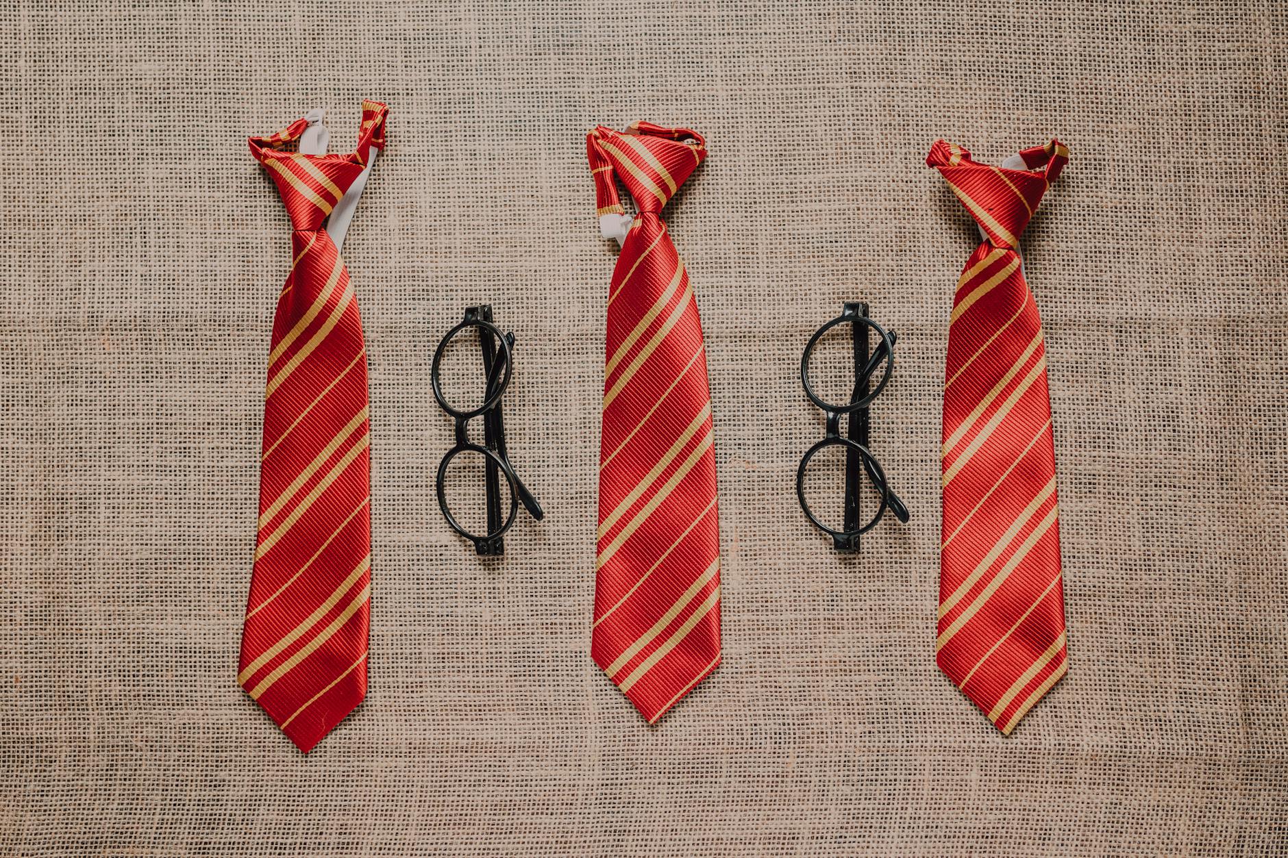 neckties and eyeglasses on brown fabric