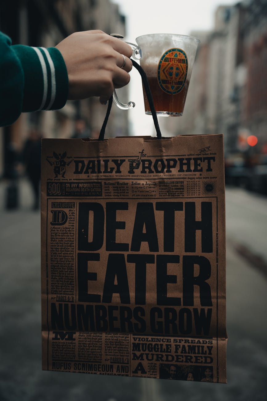 hand holding a newspaper pattern shopping bag and beer